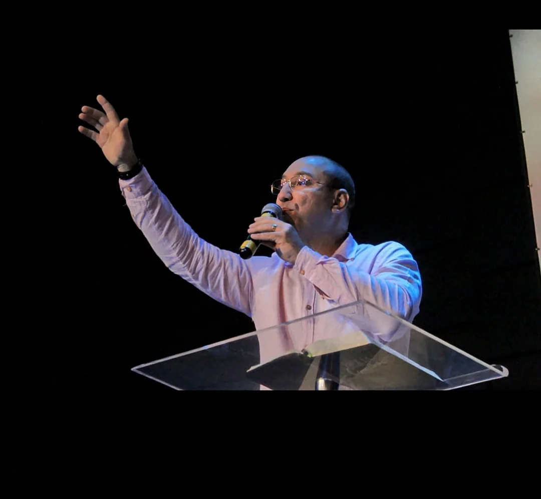 Flávio Soares palestrando no palco, microfone em punho